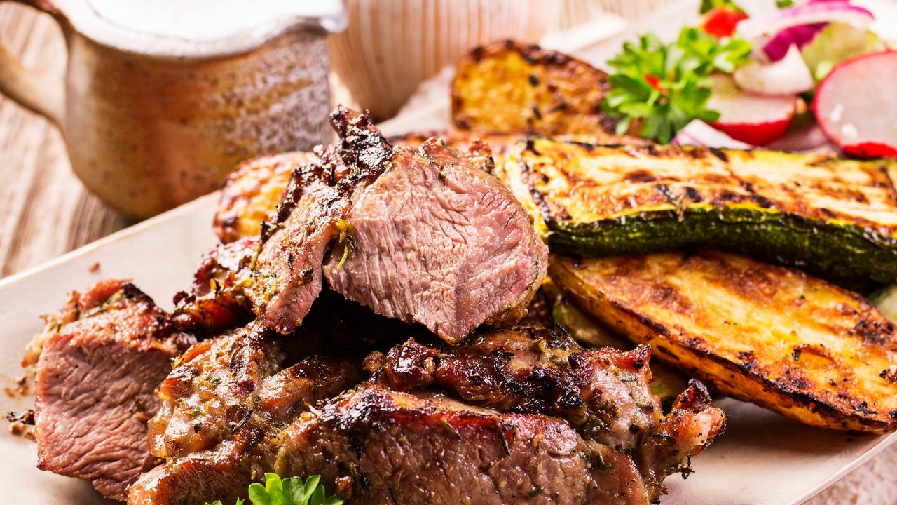 Mediterraner Lammbraten mit gebratenen Zucchini und Kartoffeln (Symbolbild)