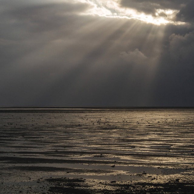 Sonnenstrahlen scheinen durch dunkle Wolken