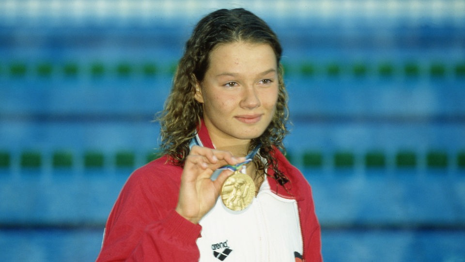 Franziska van Almsick hält ihre erste Goldmedaille 1994 hoch.